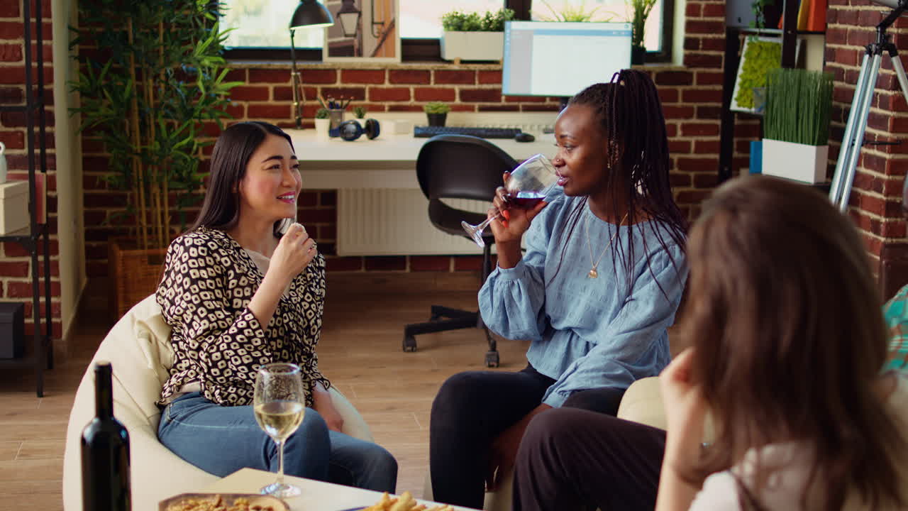 BFFs talking, drinking wine at reunion gathering, gossiping about their husbands