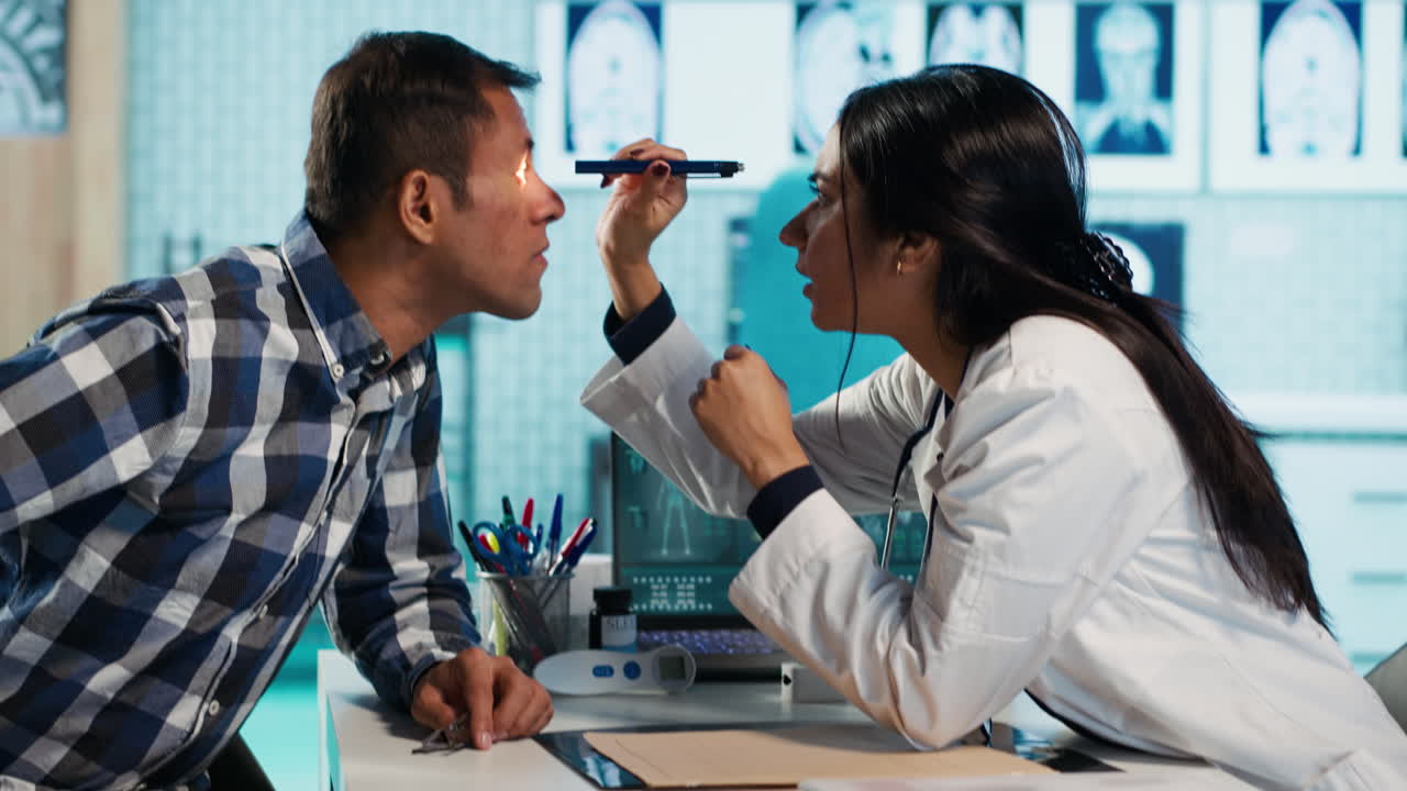 Doctor examining patient's eye with light pen