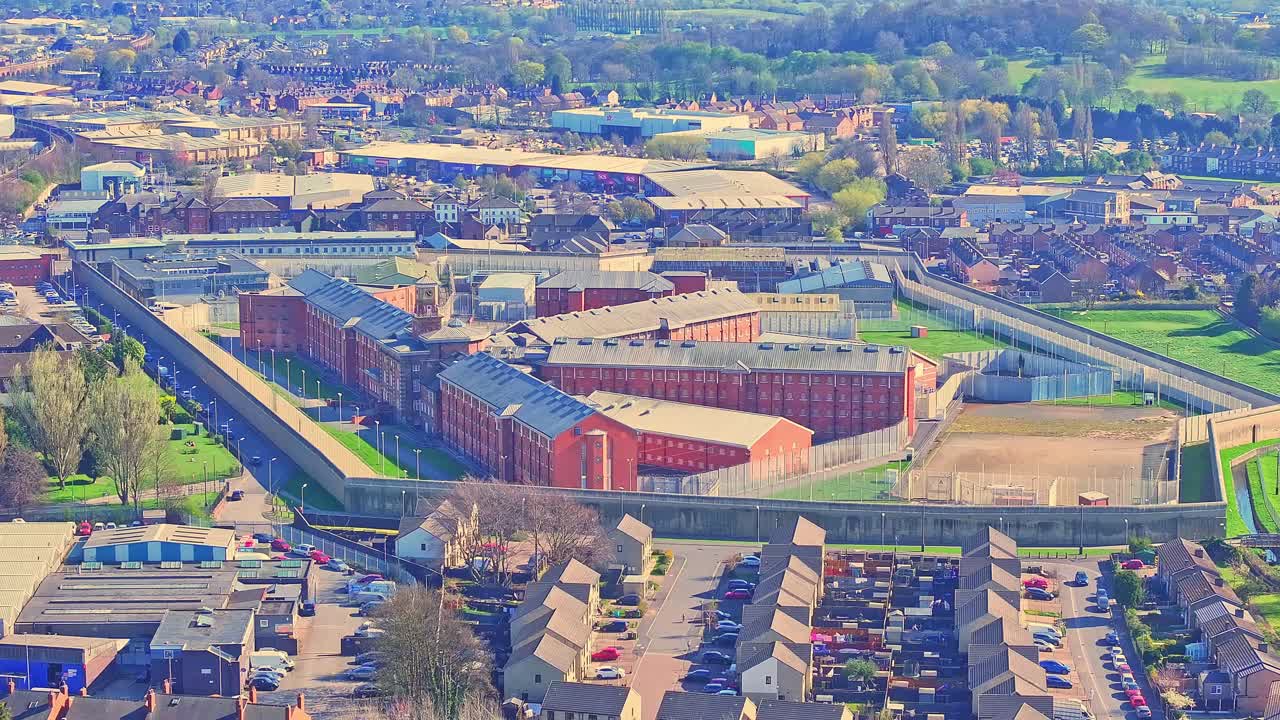 Aerial view of Wakefield city, West Yorkshire, England, reveals the imposing structure of HM Prison Wakefield, known as "Monster Mansion," nestled within the urban landscape.