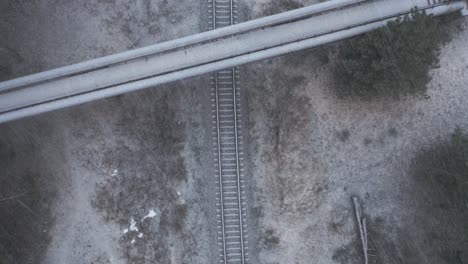 aerial: top view of overpass bridge with railway on a snowstorm