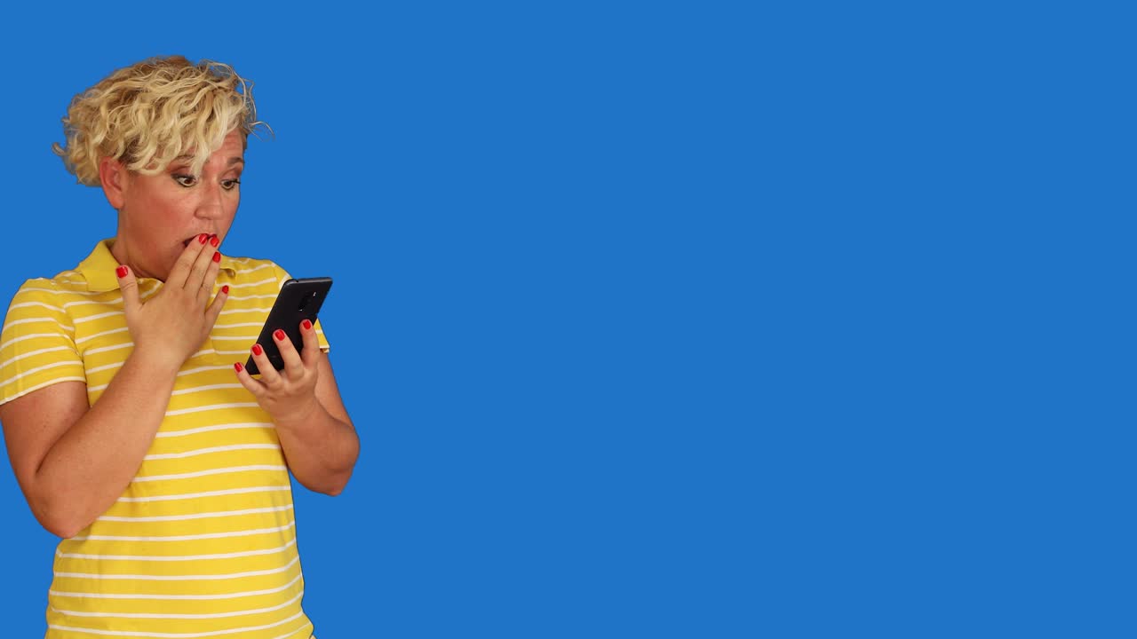 Woman looking at smartphone screen and making surprised face