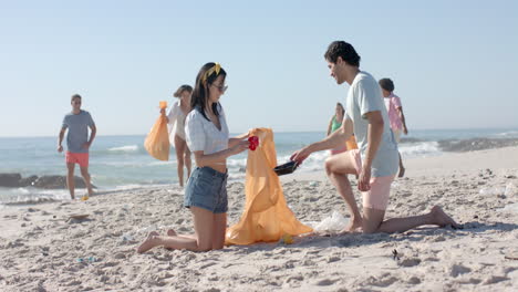 diverse young adults participate in a beach cleanup, collecting trash