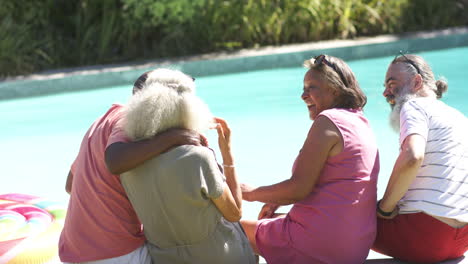 relaxing by pool, senior friends enjoying sunny day and laughing together