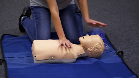 baby cpr dummy first aid training. paramedic performing cardiopulmonary resuscitation on baby dummy with chest compression
