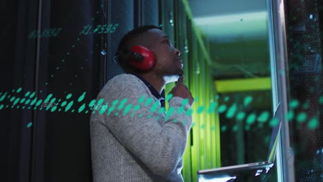 animation of data processing on thoughtful african american male engineer with laptop at server room