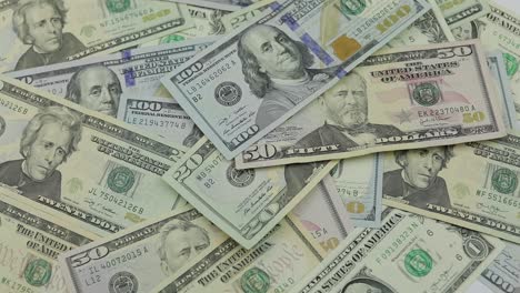 dollar bills fall on the table with american dollars of different denominations