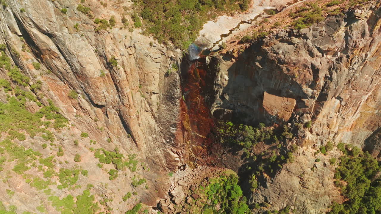 Dried waterfall in Yosemite National Park, California, USA. Steep cliffs with some vegetation on. View from top.