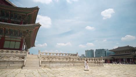 gyeongbokgung palace - korean couple wearing traditional hanbok royal costumes travel inside geunjeongjeon hall on summer day - copy space