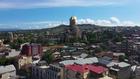 aerial: tbilisi city reveal, metekhi church in background, georgia capital