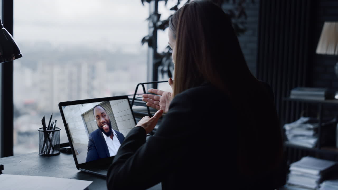Office manager chatting webcam laptop with client close up