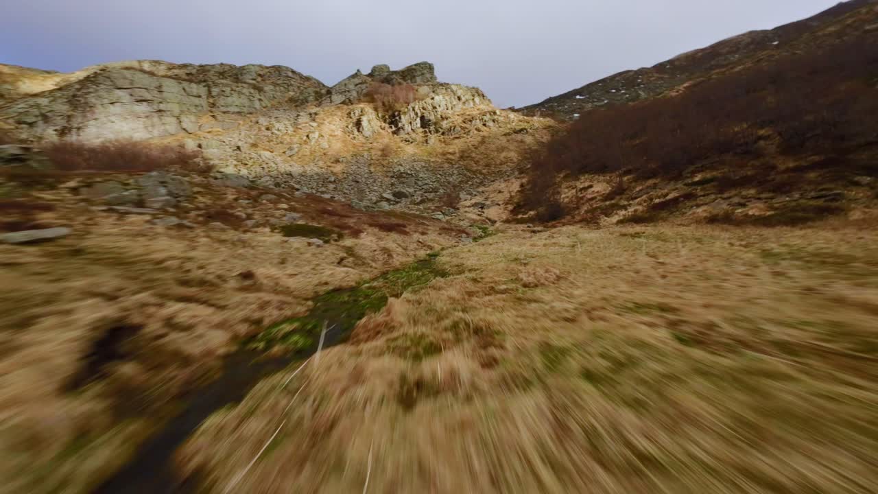 Fast drone dive through rocky Dolomites with golden grass and steep mountain slopes