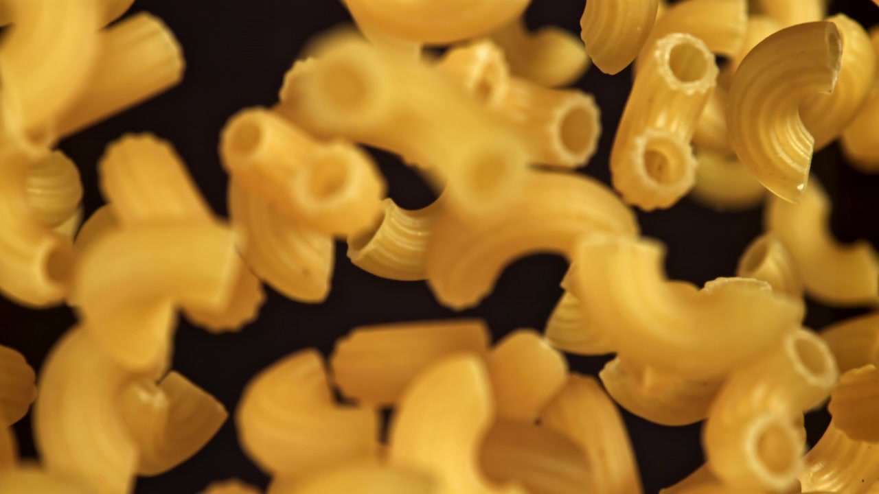 Pasta maccheroni secca che entra a fuoco al rallentatore