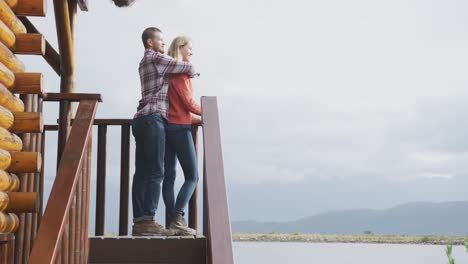 pareja caucásica pasando el tiempo en casa juntos, abrazándose y mirando la vista