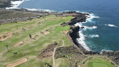 high angle establish of perfect golf course on rocky sea cliffs overlooking the ocean