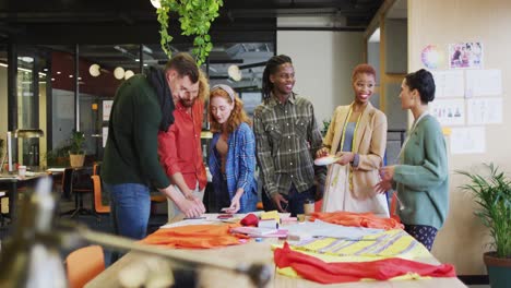 Happy-diverse-business-people-discussing-work-with-documents-at-office