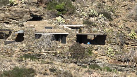 aerial view orbiting stunning stone built house on the cliffs of cap de creus national park rocky mountainside