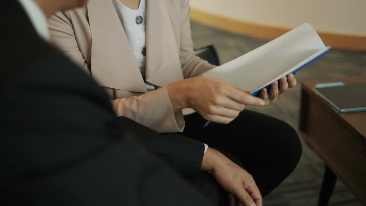 Broker assicurativo sanitario che spiega il piano a un cliente cinese in ufficio.
