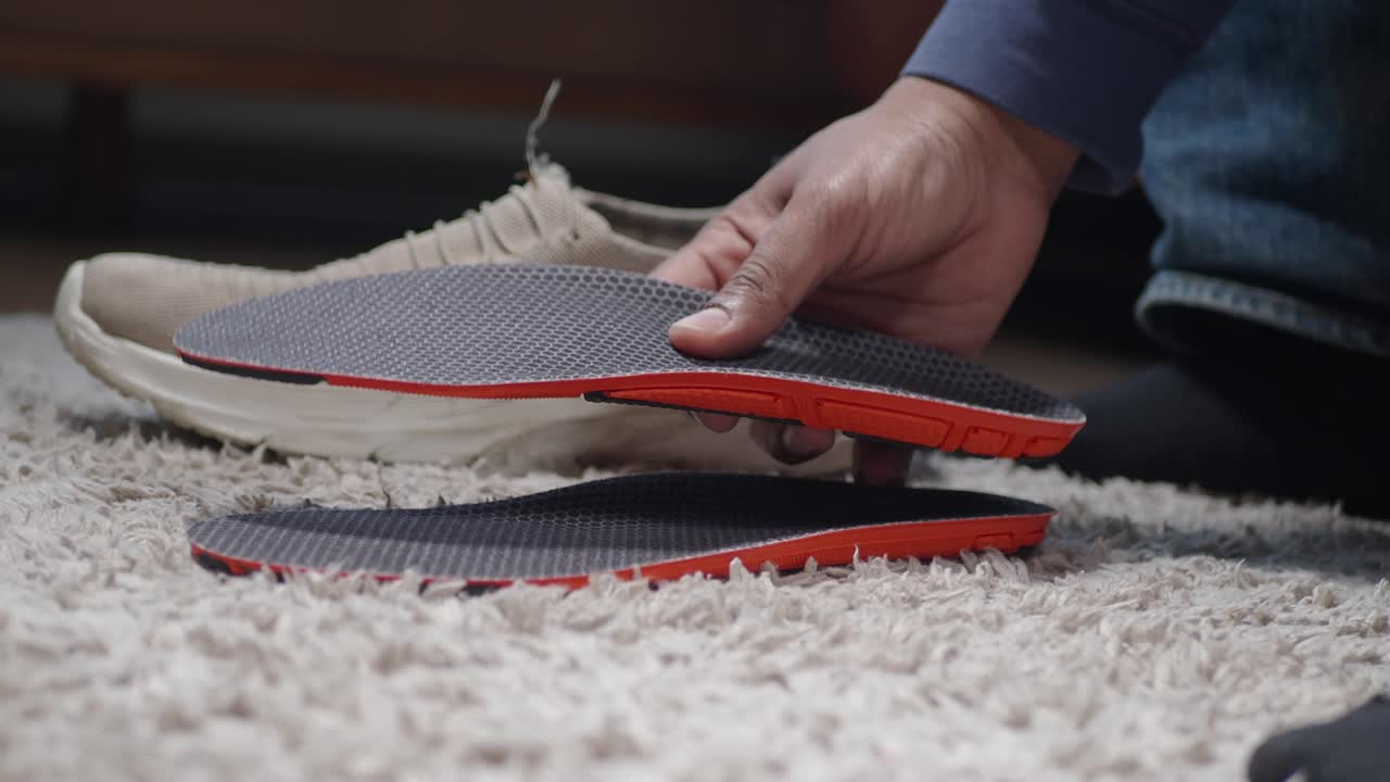 Uomo che tiene delle solette per scarpe
