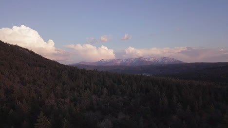 Incredible-aerial-shot-of-snow-capped-mountains-and-a-vast-forest-in-America