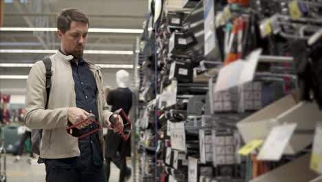 man looking at electronics in a store