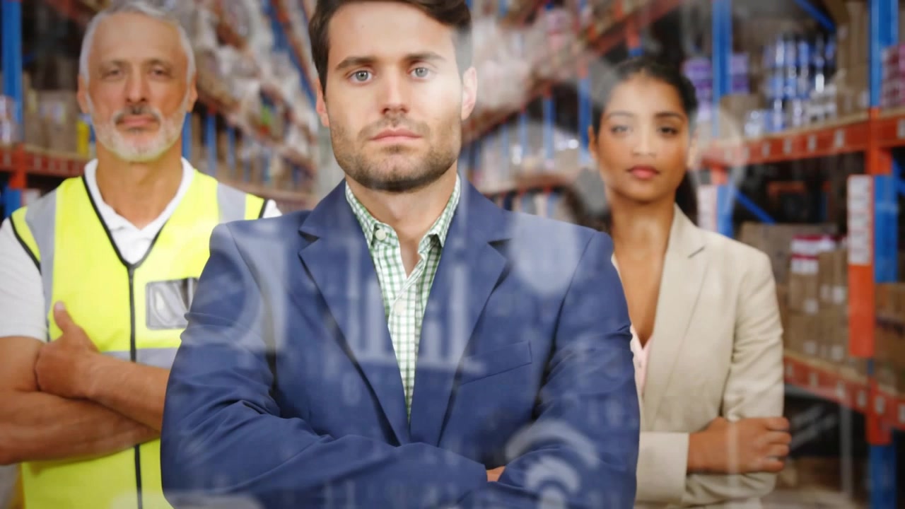 La telecamera si allontana, con sovrapposizioni tecnologiche che emergono, un uomo in blazer blu scuro che presenta il team e mostra le operazioni di magazzino.