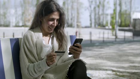 Mujer-Sonriente-De-Mediana-Edad-Escribiendo-El-Número-De-Tarjeta-En-El-Teléfono-Inteligente.