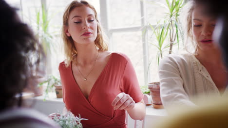 Dos-Mujeres-Blancas-Adultas-Jóvenes-Almorzando-En-Una-Mesa-En-Un-Restaurante-Con-Amigos,-De-Cerca,-El-Enfoque-Selectivo