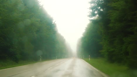 slowmo racking focus from rainy windshield to car approaching, black forest, germany