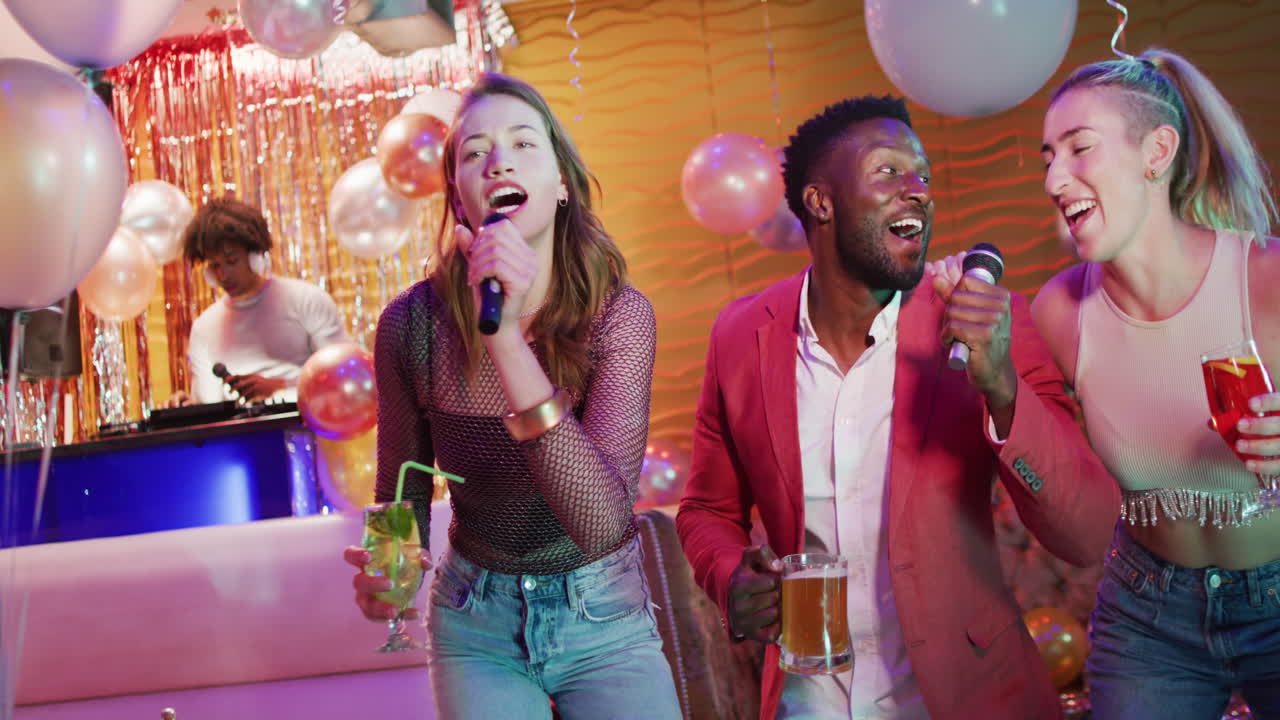 Video of diverse happy group of friends signing karaoke at a nightclub bar