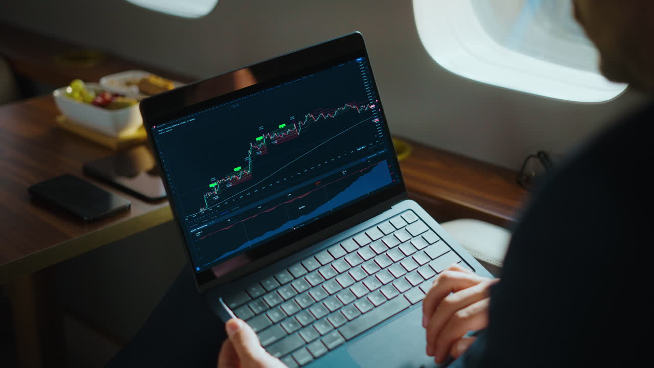 Businessman Analyzing Stock Market on Laptop in Private Jet