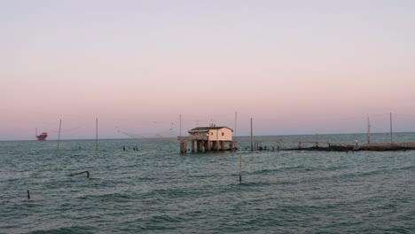 aerial shot of the valleys near ravenna where the river flows into the sea with the typical fishermen's huts at sunset