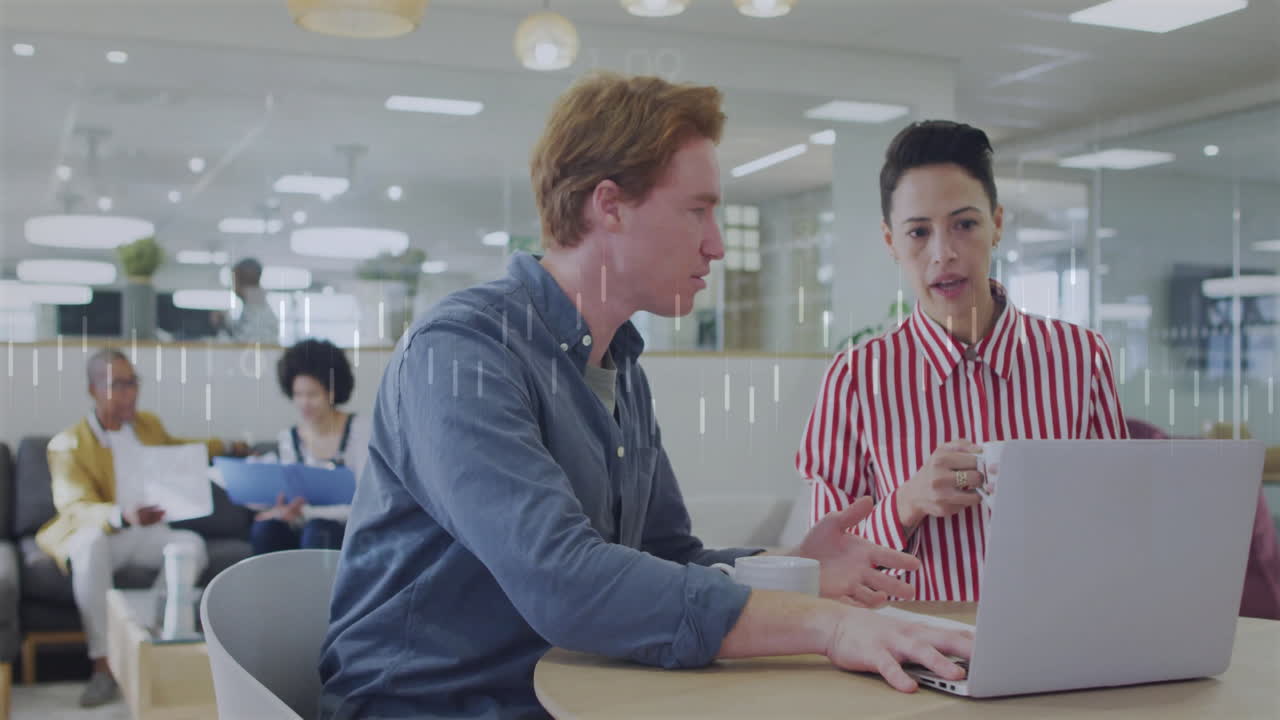 In office, colleagues discussing work using laptop, focusing on animation project