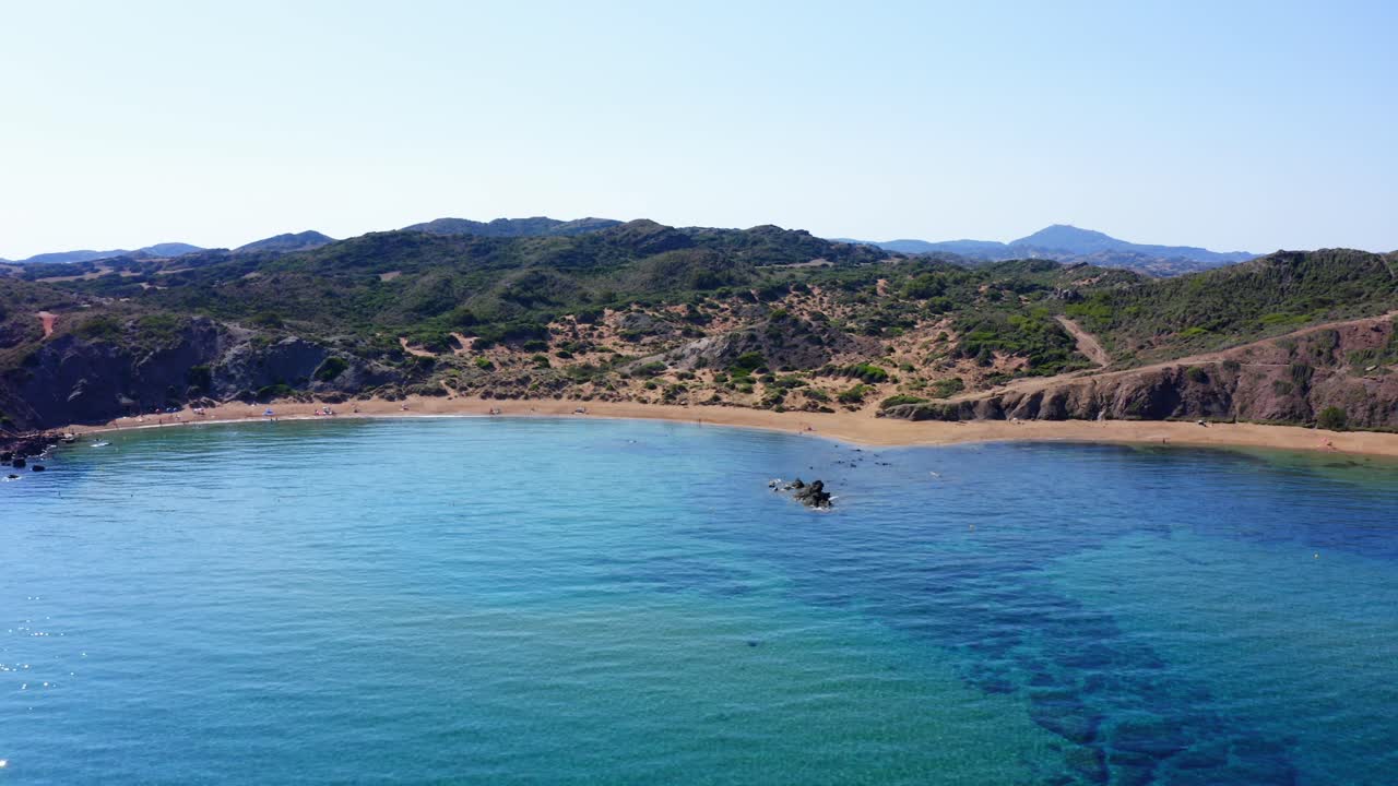 European summer with drone flying across the waters of Menorca on sunny day with no clouds