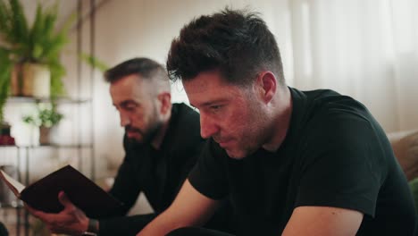 quiet emotional pause shared by two men in a softly lit room