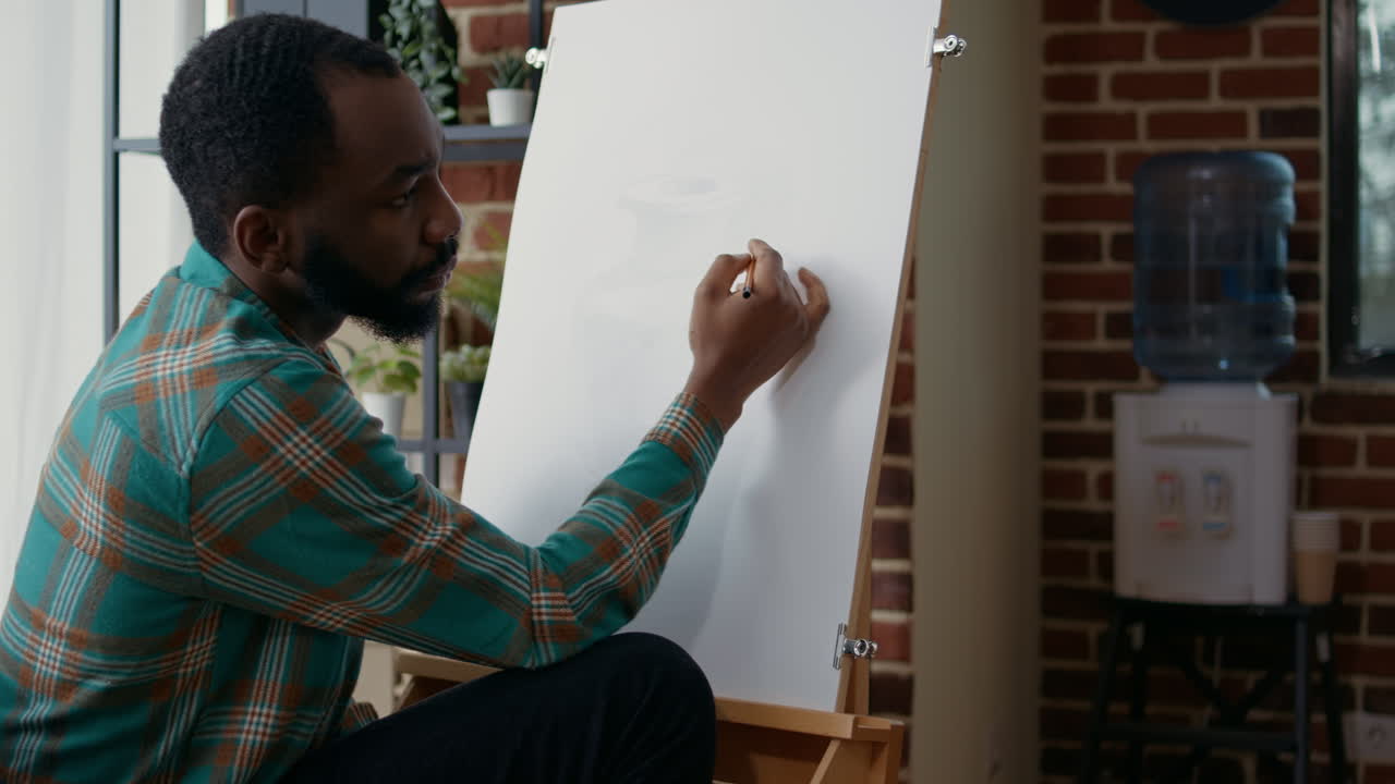 Young man learning drawing technique on canvas at art class lesson