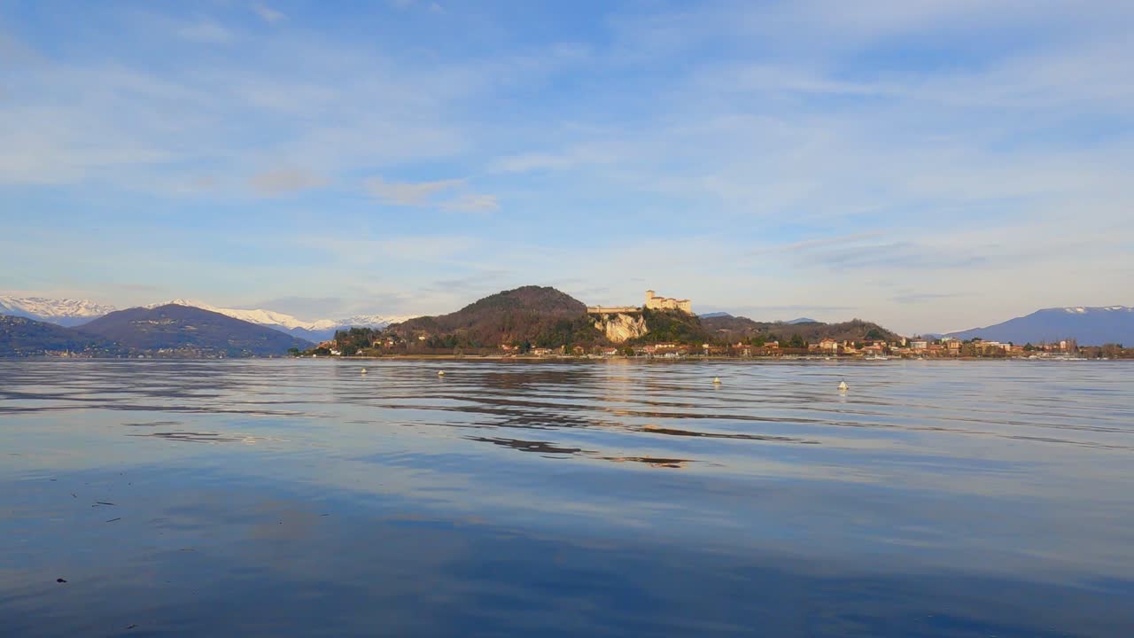 fortaleza de angrya en el lago maggiore con montañas nevadas en el fondo, italia