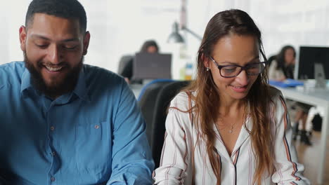 young people sitting at table at office space