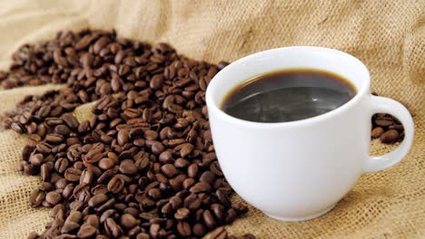 café negro servido en saco con granos de café