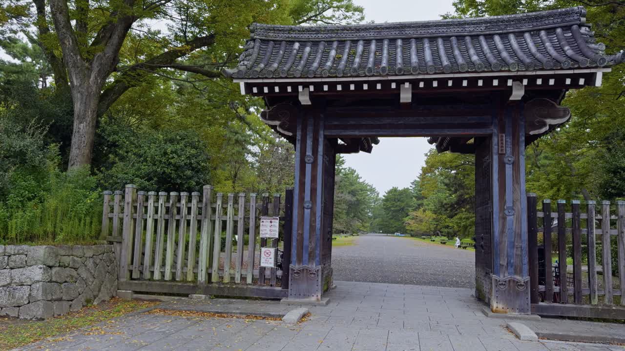 традиционные японские ворота ведут в спокойный сад киото, окруженный природой.