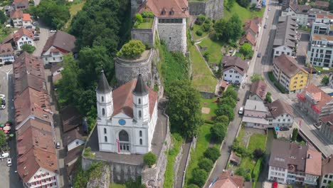 Sweeping aerial showing fortress from above with rooftops fanning out below