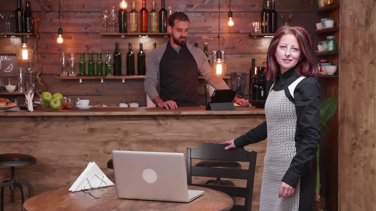People in a cafe with a laptop on a table
