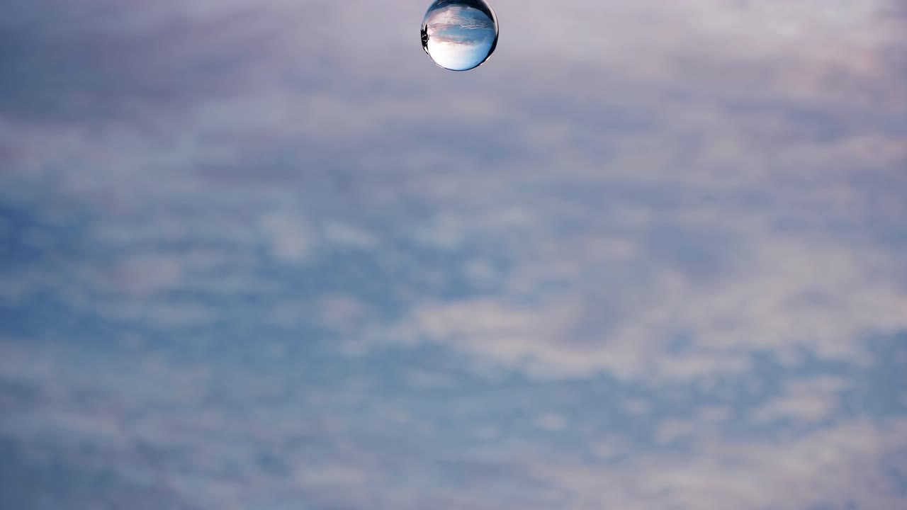 A mesmerizing close-up video captures a water droplet splashing, creating a crown-like effect