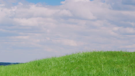 colina verde contra el cielo azul con nubes