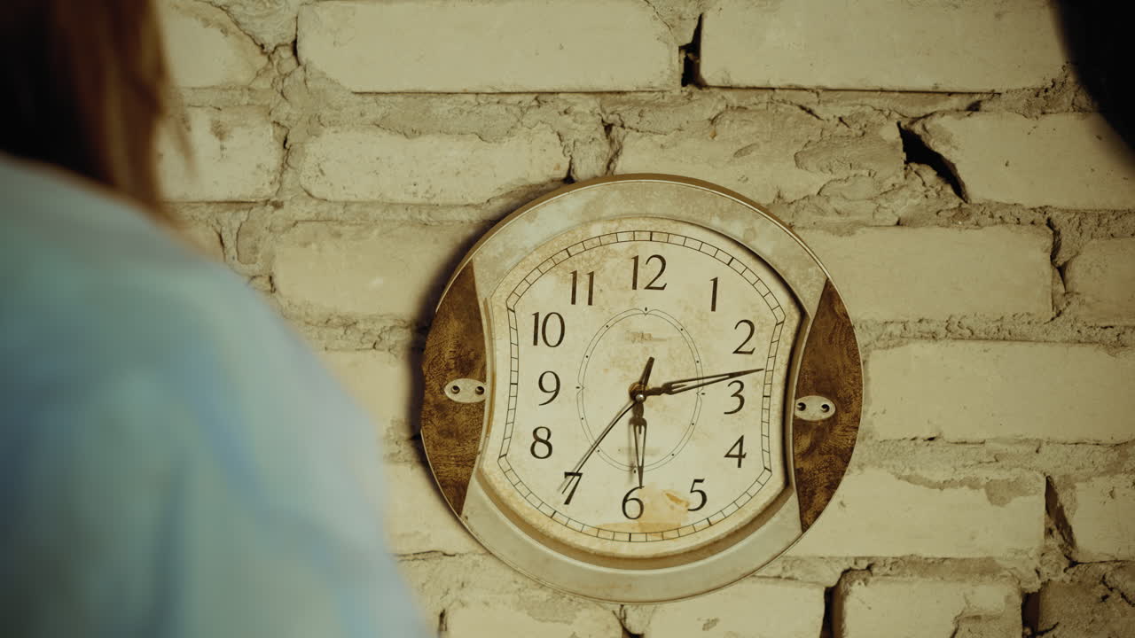 Close up rear view of person in protective clothing adjusting old vintage wall clock on cracked brick wall, symbolizing survival, passage of time and endurance in abandoned shelter atmosphere