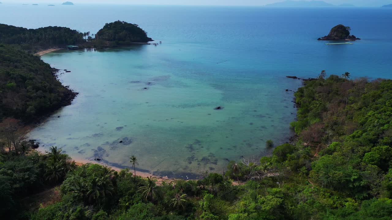 Koh Mak tropical island in Thailand showing turquoise water and green rainforest. Tremendous aerial view flight descending drone