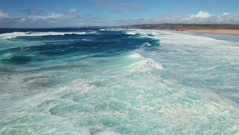 Aerial-drone-4k-capturing-dynamic-motion-and-intricate-patterns-of-the-ocean's-movement-revealing-the-beauty-and-power-of-the-crashing-waves-against-the-shoreline-in-the-algarve-region-of-Portugal