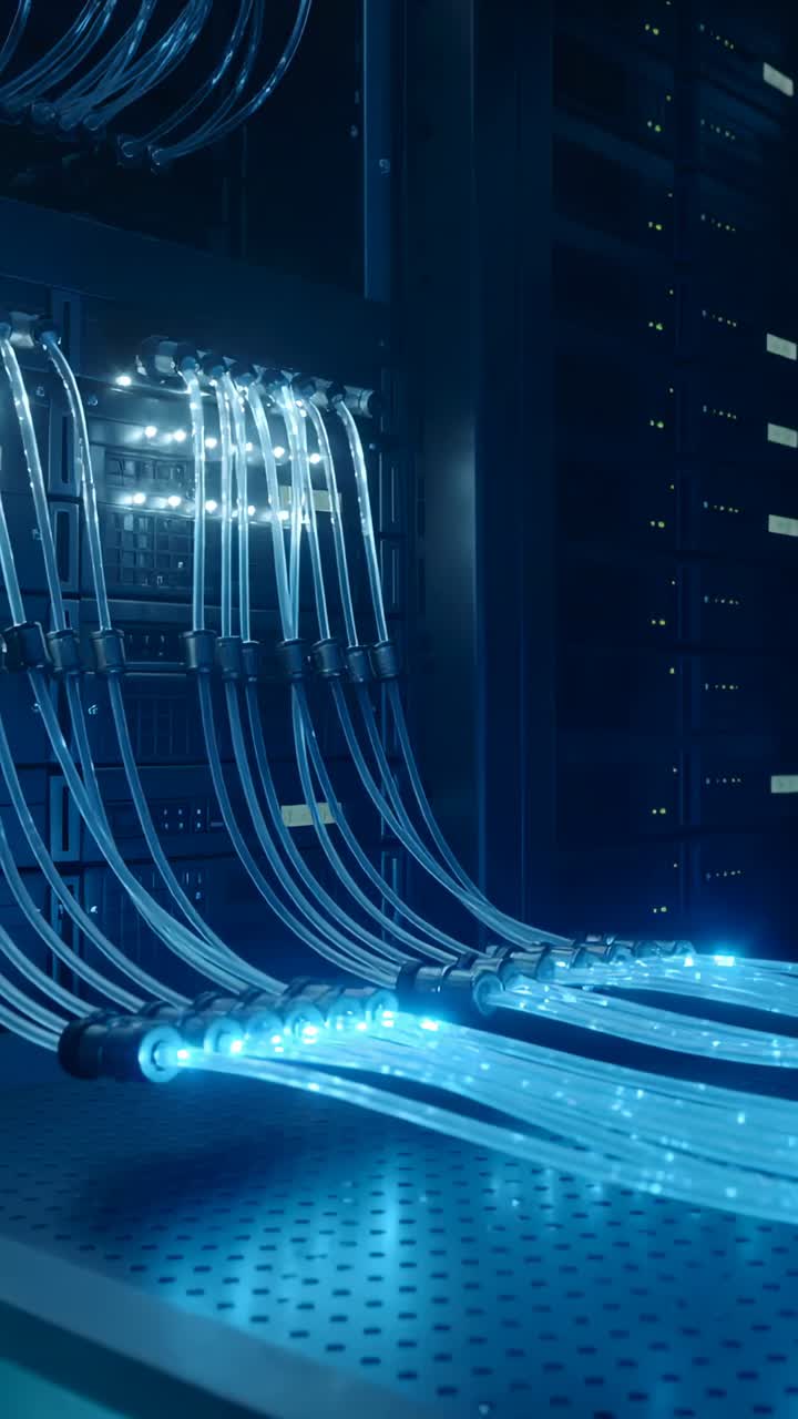 Vertical video: Pulsing fiber cables moving while camera shifting in data rack to reveal connectors