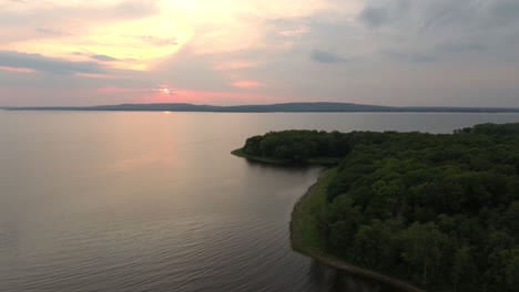 puesta de sol colorida que hace que las nubes sean rosas vistas por un dron que vuela sobre la costa