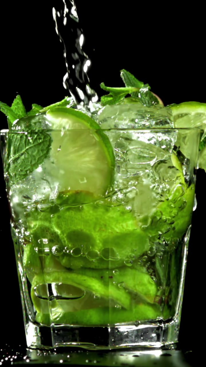 Nestettä kaadetaan virkistävään mojito-cocktailiin limen ja mintun kera