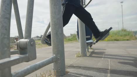 Pair-of-adult-legs-working-out-on-exercise-equipment-outside,-slow-motion